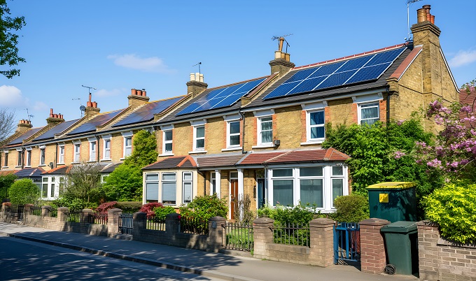 a row of houses with solar panels on the roofs